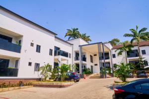a parking lot in front of a building with palm trees at Aurum on Missouri in Abuja