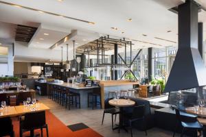 a restaurant with tables and chairs and windows at Hôtel & Spa Le Germain Charlevoix in Baie-Saint-Paul