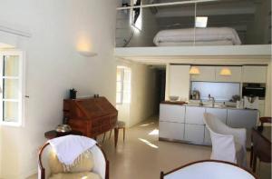 a living room with a table and chairs and a kitchen at L’Ile Rousse les pieds dans l’eau in LʼÎle-Rousse
