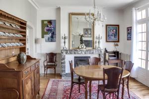 a dining room with a table and a fireplace at La Maison Carteret in Montier-en-Der