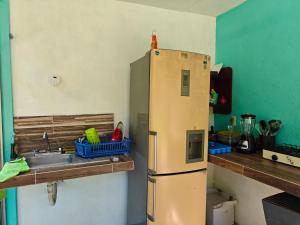 a kitchen with a sink and a refrigerator at Bacalar La Fortuna Cabañas a 300m de la Laguna in Bacalar