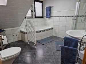 ein Badezimmer mit Waschbecken, Badewanne und Toilette in der Unterkunft Panoramablick Eitelborn in Eitelborn + 18 Fotos