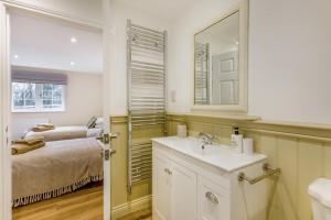 a bathroom with a sink and a bed with a mirror at 3 Bed in Callaughton oc-b34809 in Much Wenlock +17 photos