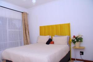 a bedroom with a large bed with a yellow headboard at Wakanda in Johannesburg