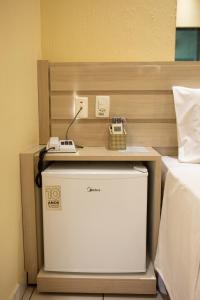a room with a bed with a phone on a table at Polar Rio Hotel in São Paulo