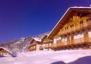 a ski lodge in the mountains with snow on the ground at Beautiful chalet accommodation with covered parking in Cianfuran