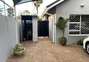 a house with a potted plant on a brick patio at Urban Oasis Gaborone "Secure Quiet Luxury in the City" near the CBD in Gaborone