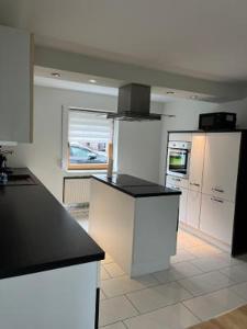 a kitchen with white cabinets and a black counter top at CasaCremer 3 in Übach-Palenberg +8 photos