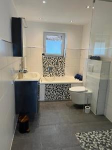 a bathroom with a tub and a toilet and a sink at CasaCremer 3 in Übach-Palenberg