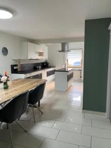 a large kitchen with a wooden table and chairs at CasaCremer 3 in Übach-Palenberg