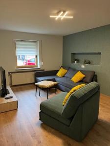 a living room with a blue couch and yellow pillows at CasaCremer 3 in Übach-Palenberg