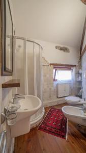 a bathroom with two sinks and a tub and two toilets at Dolomites Luxury Penthouse in Agordo +44 photos