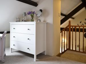 a white dresser in a room with a staircase at The Nook in Amroth +10 photos