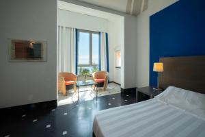 a hotel room with a bed and a table and chairs at Hotel Punta San Martino in Arenzano +48 photos