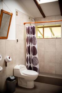 a bathroom with a toilet and a shower curtain at Casita Huaran in Calca