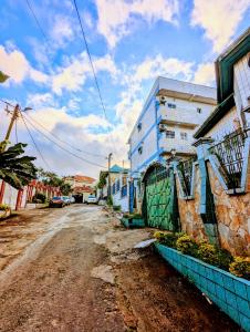 an empty street with a blue building on the side at Appartement Meublé 3 Chambres in Douala