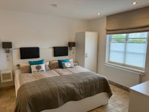 a bedroom with a large bed with blue pillows at Ferienhaus Leegwater in Munkmarsch +64 photos