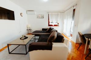 a living room with two couches and a table at Apartman Deja vu in Livno