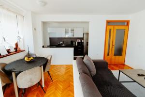 a kitchen and a living room with a couch and a table at Apartman Deja vu in Livno