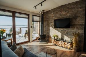a living room with a brick wall and a fireplace at Apartamenty Fuleda nad jeziorem Dobskim Mazury Holiday in Fuleda