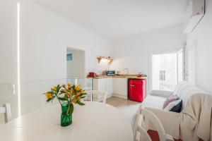a living room with a white table and a red refrigerator at Seafront Apartments in Monopoli Old Town in Monopoli
