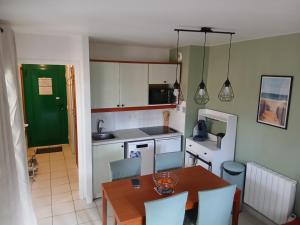 a kitchen with a table and chairs and a kitchen with a table and a kitchen at Appartement Carcans Maubuisson in Carcans