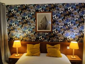 a bedroom with a bed with two lamps and a picture of a boat at Appartement Carcans Maubuisson in Carcans