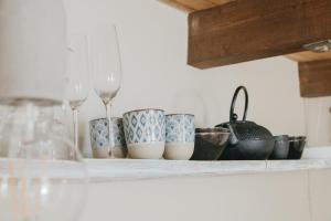 a shelf with wine glasses and bowls on it at Flusshaus BnB Alicudi in Brugg