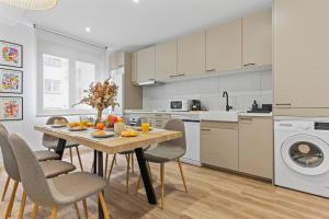 a kitchen and dining room with a table and chairs at Picasso, para 6 personas, espacioso piso de diseño in Gijón