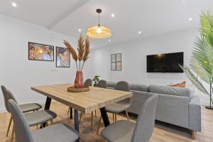 a dining room with a table and chairs and a couch at Picasso, para 6 personas, espacioso piso de diseño in Gijón