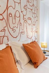 a bed with orange pillows in a bedroom at Picasso, para 6 personas, espacioso piso de diseño in Gijón
