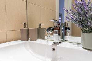 a bathroom sink with a faucet and a mirror at Plaza del Carmen in Gijón +12 photos