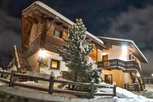 a log cabin with a christmas tree in the snow at Livigno Chalets in Livigno