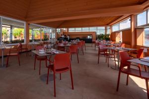 a dining room with tables and chairs and windows at Hotel Punta San Martino in Arenzano