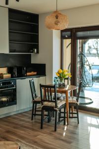 a kitchen with a dining room table and chairs at Apartamenty Fuleda nad jeziorem Dobskim Mazury Holiday in Fuleda