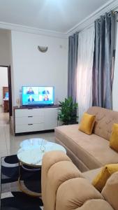 a living room with a couch and a tv at Olympus studio 1 in Yaoundé