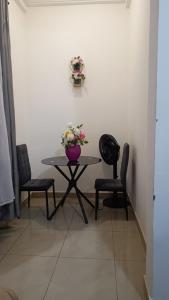 a table with two chairs and a vase of flowers on it at Olympus studio 1 in Yaoundé