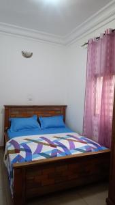 a bedroom with a bed and a pink curtain at Olympus studio 1 in Yaoundé