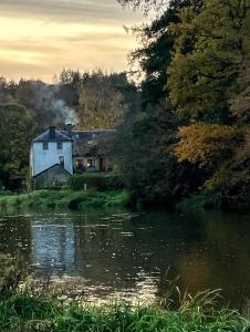 a house sitting next to a body of water at caravan hereumond in Cugnon