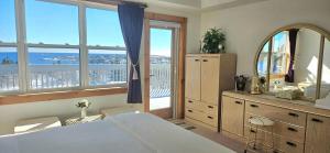 a bedroom with a large bed and a large window at Panoramic Sunrise House in Terence Bay