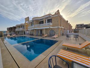 a swimming pool in front of a building at Soltan palace in Qaryat Wādī ‘Abbādī 1