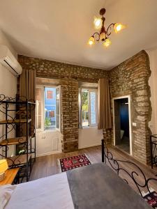 a bedroom with a bed and a stone wall at InTown Guesthouse Shkoder in Shkodër