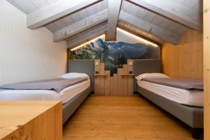 two beds in a room with a large window at Livigno Chalets in Livigno