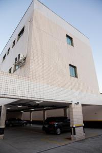 a building with a car parked in a parking lot at Polar Rio Hotel in São Paulo