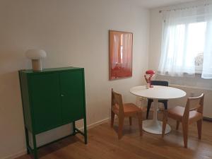 a room with a green cabinet and a table and chairs at Casa Stetten in Lörrach
