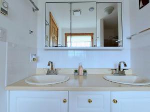 a bathroom with two sinks and a mirror at Panoramic Sunrise House in Terence Bay +83 photos