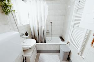 a white bathroom with a tub and a sink at Apartman Deja vu in Livno +30 photos