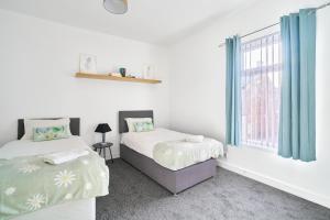 a bedroom with two beds and a window at Craigs Nook in Darlington