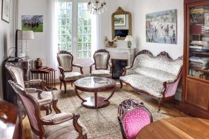 a living room with chairs and a couch and a table at La Maison Carteret in Montier-en-Der