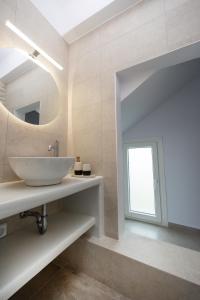 a bathroom with a sink and a mirror at Naxos Cube Villa Panoramic Views Maisonette with Sea View 2 min walk to Plaka Beach in Plaka +59 photos